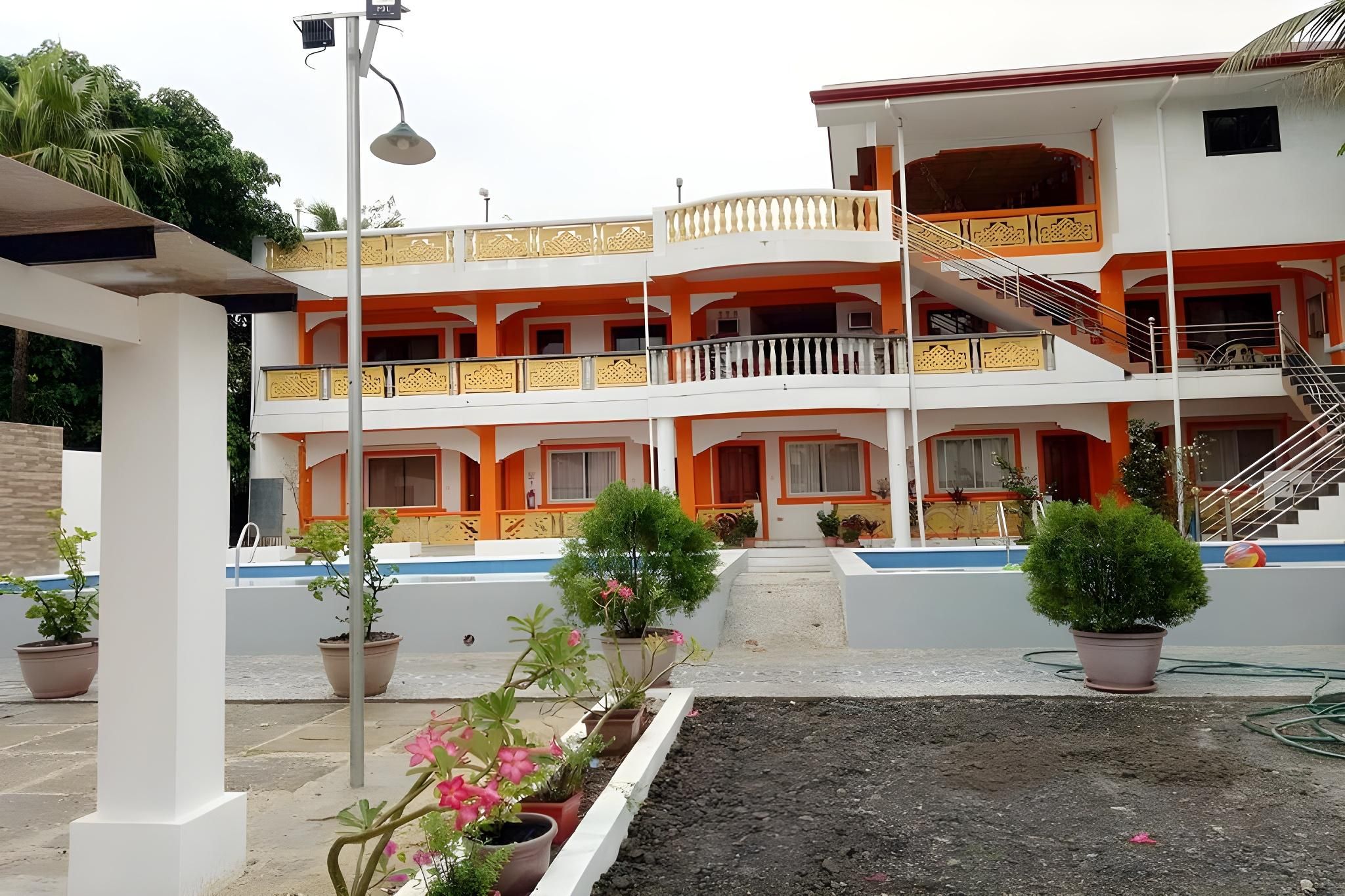 Un edificio de varios pisos con balcones, una escalera y plantas en macetas.