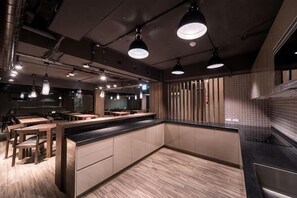 A modern kitchen with wooden flooring, a central island, and pendant lighting. - Huada Hotel (Taipei)