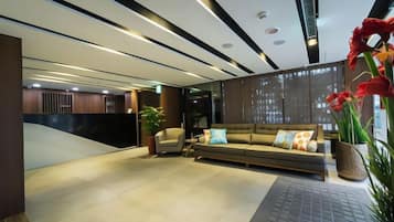 A modern interior with a sofa, a small table, and a potted plant.