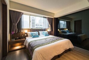 A hotel room with a large bed, a window with curtains, a nightstand, and a view of the city. - Huada Hotel (Taipei)