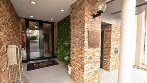 A hotel entrance with a stone facade, a glass door, and a sign that reads 'RANDOR'. - Randor Residence Tokyo Classic (Tokyo)