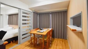 A compact hotel room with a bed, a desk, a chair, a TV mounted on the wall, and a sliding door closet. - Randor Residence Tokyo Classic (Tokyo)