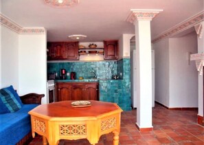 Cozy seating area with a traditional dining table and kitchen in the background.