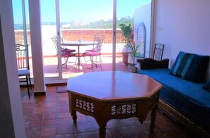 Enjoy a patio with a round table, four chairs, and a sofa, offering a view of the surrounding landscape.