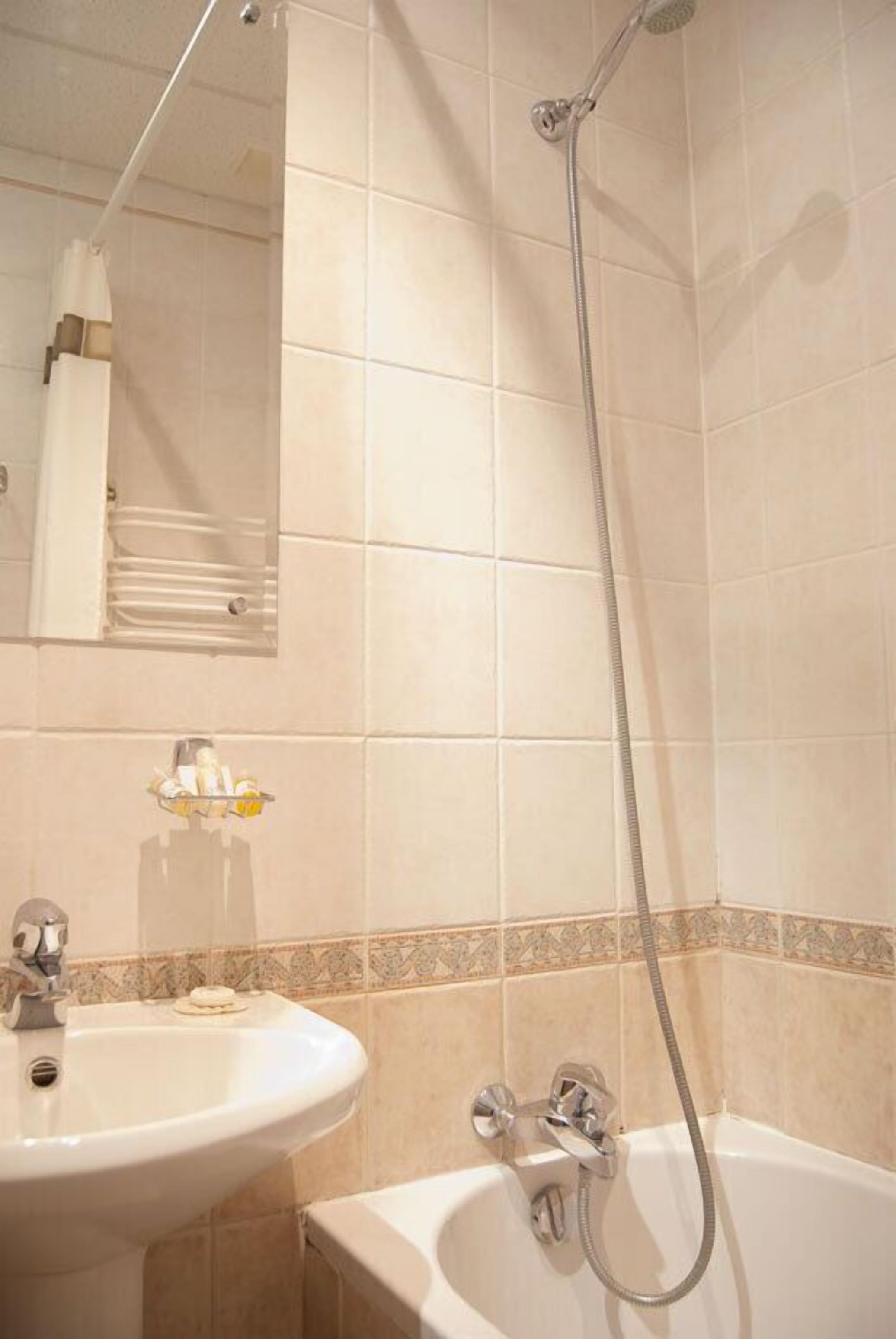 Een badkamer met een wastafel, badkuip en douche.