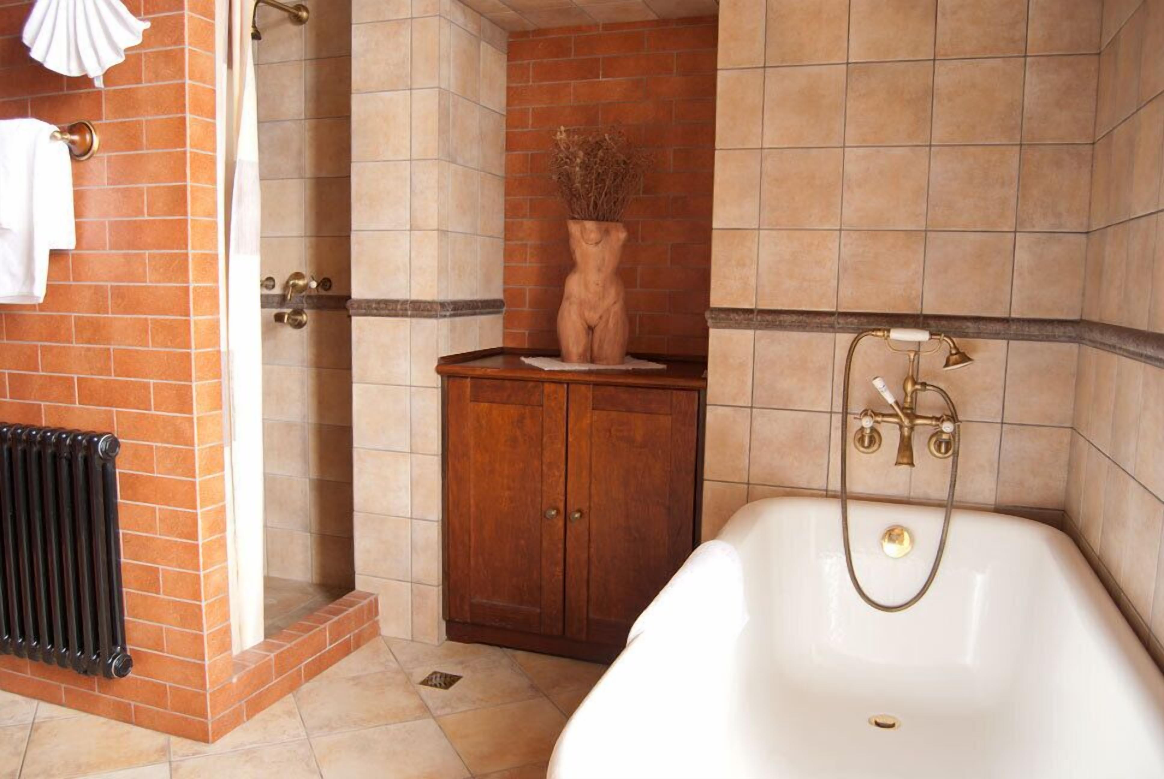 A bathroom with a bathtub, a wooden cabinet, and a radiator.