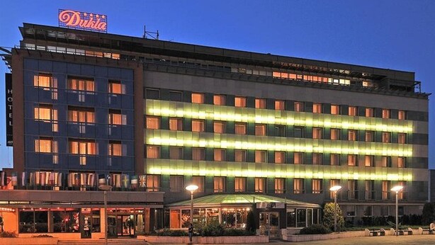 A hotel with a prominent sign, multiple floors, and a well-lit facade. - Dukla Presov (Prešov)