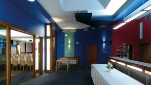 A hotel room with a large bed, a desk, and a seating area with chairs. - Dukla Presov (Prešov)