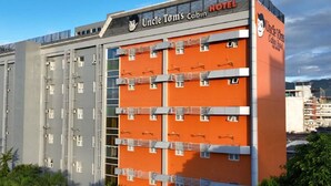 Un edificio de varios pisos con una fachada anaranjada llamativa y un cartel que dice 'Uncle Tom's Cabin Hotel'.