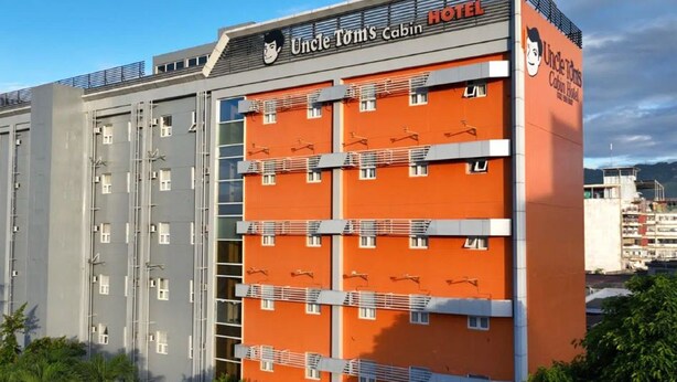 A multi-story building with a prominent orange facade and a sign reading 'Uncle Tom's Cabin Hotel.' - Uncle Tom's Cabin Hotel (Cebu City)
