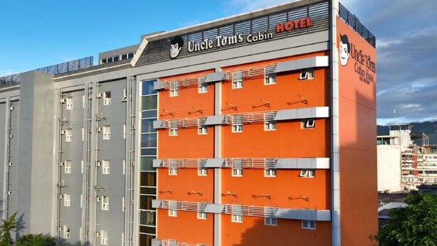 A multi-story building with a prominent orange facade and a sign reading 'Uncle Tom's Cabin Hotel.' - Uncle Tom's Cabin Hotel (Cebu City)