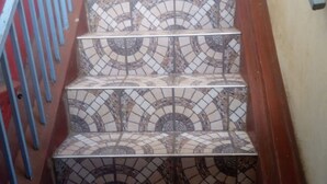Eine Treppe mit einem gemusterten Fliesenbelag und blauen Geländern.