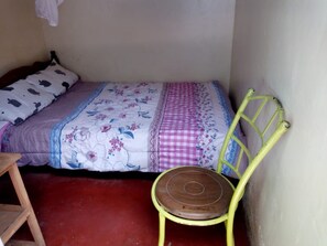 A small, single-bed room with a wooden chair and a wooden ladder. - Jostem Inn (Ruiru)
