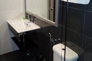 Um banheiro moderno com pia, espelho e vaso sanitário brancos.