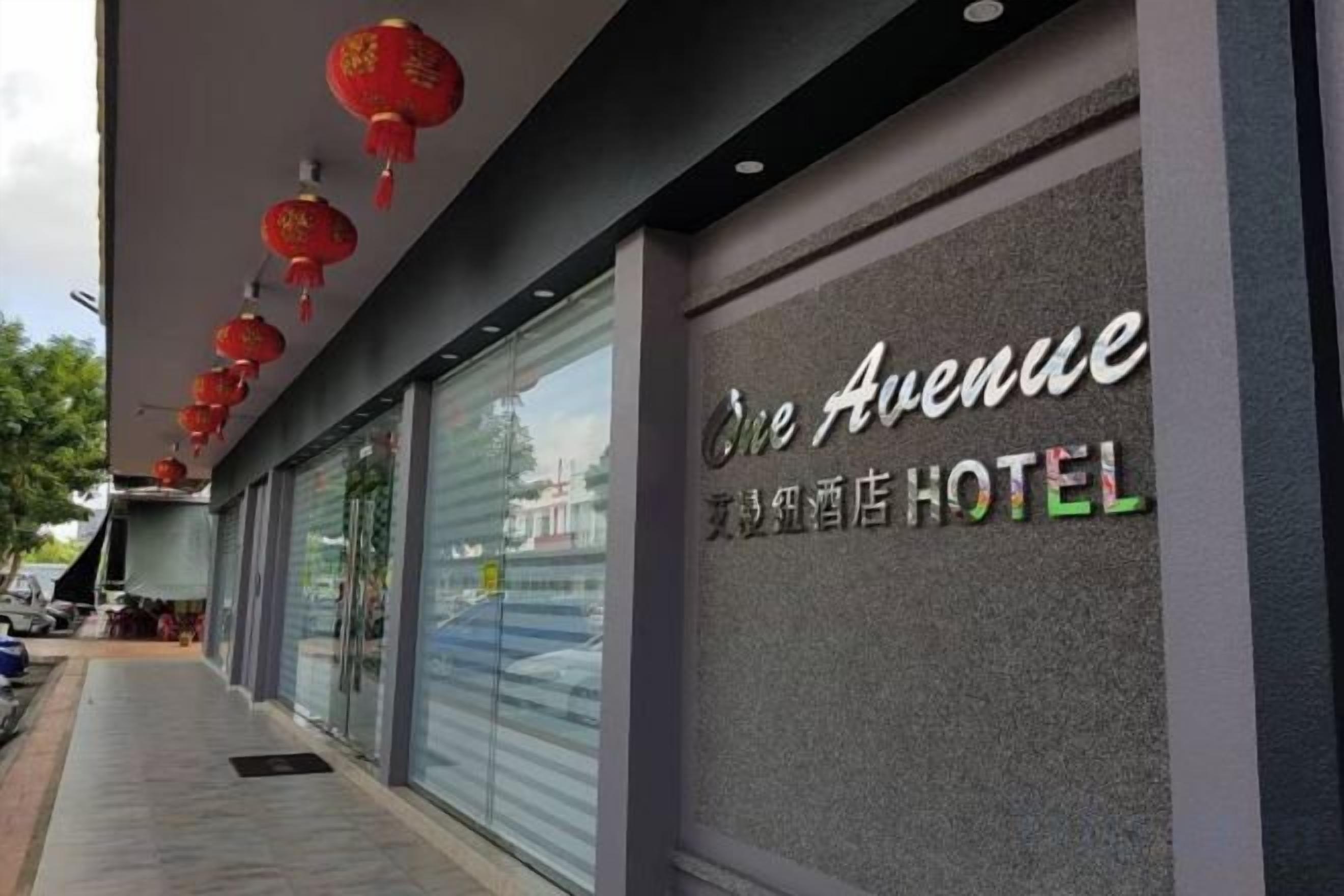 Un hôtel dont l’enseigne porte l’inscription « One Avenue » ainsi que des caractères chinois.