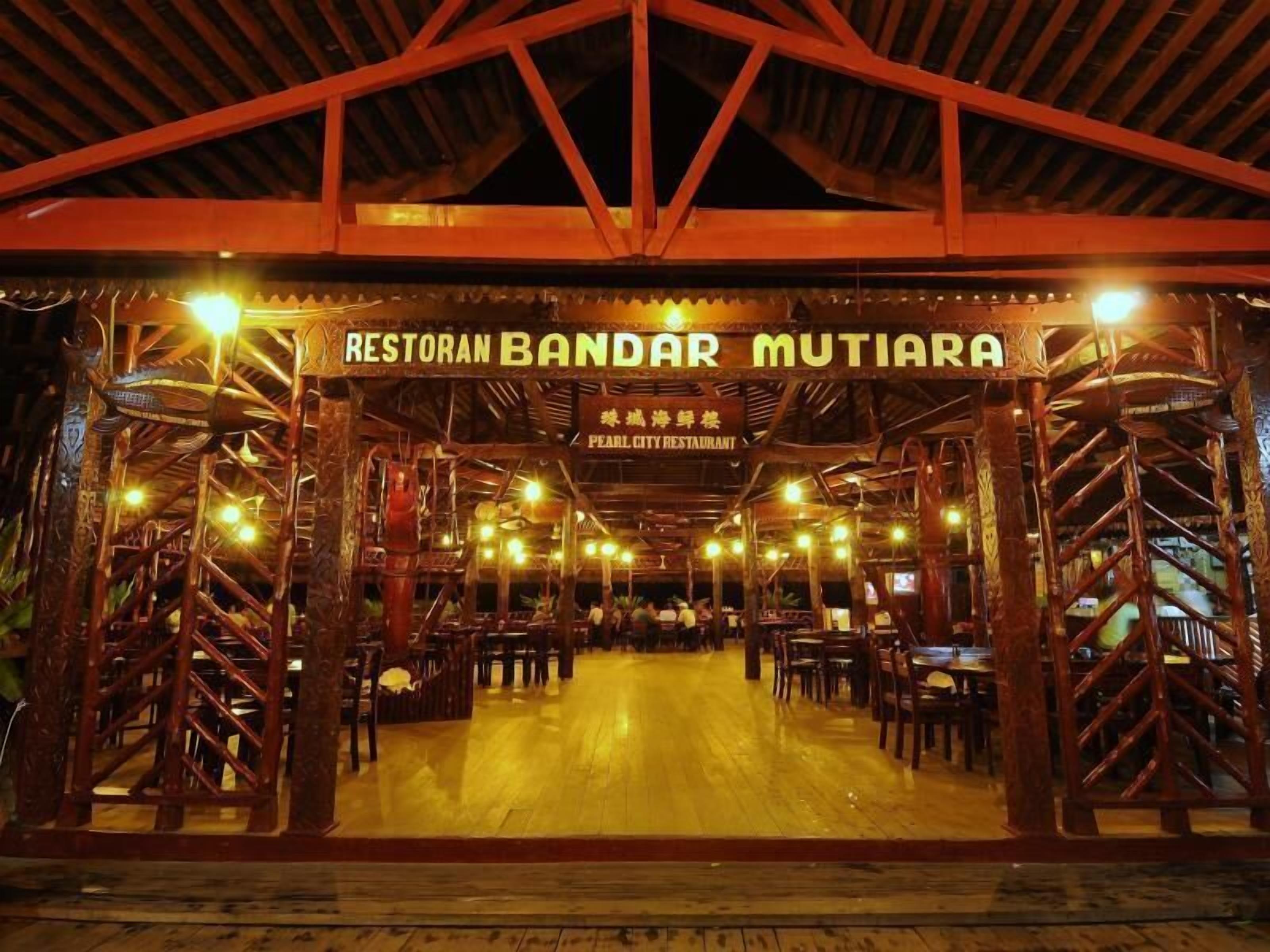 A restaurant with a wooden structure and a sign that reads "Restoran Bandar Mutiara."