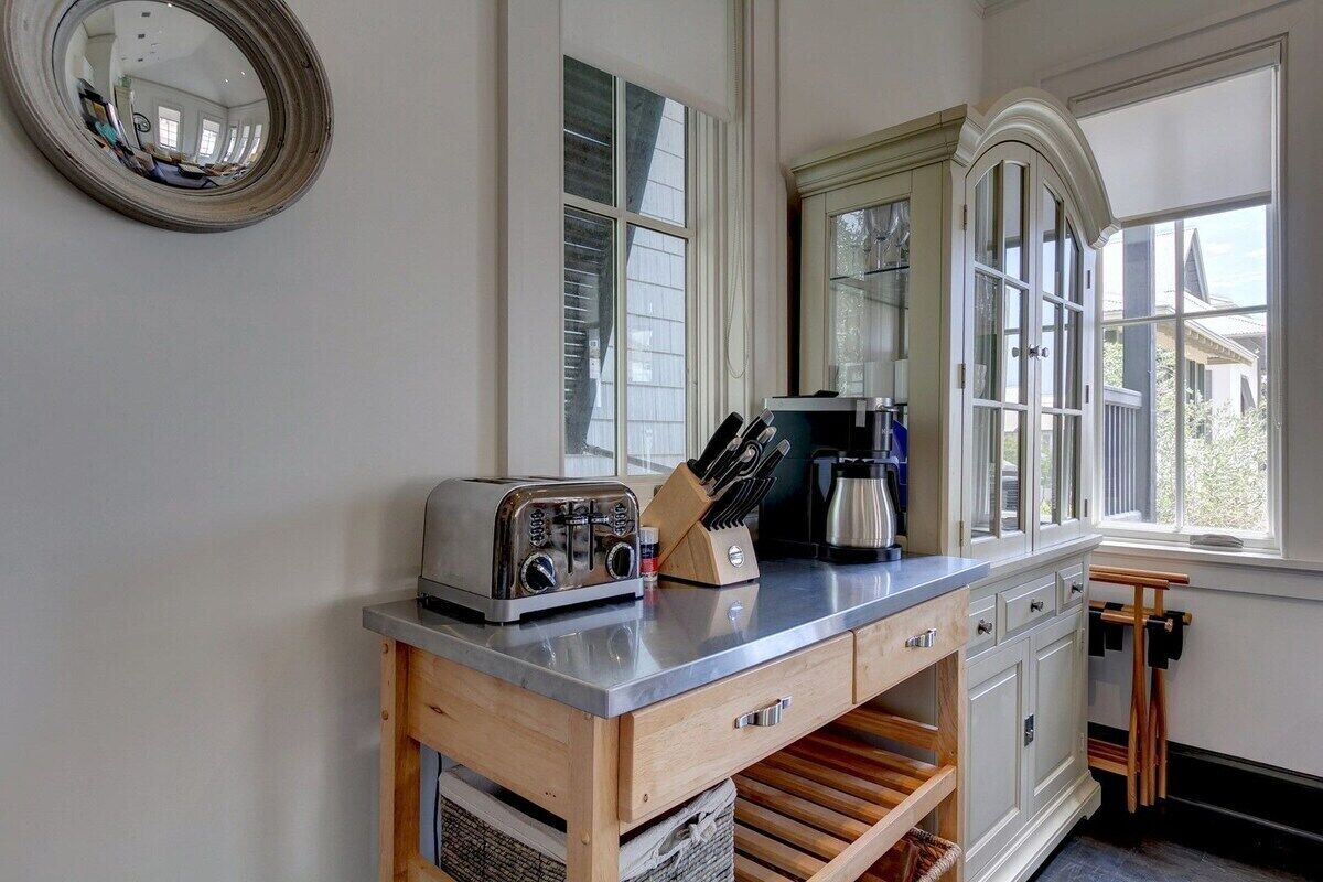 A kitchen with a wooden counter, a toaster, a coffee maker, and a knife block.