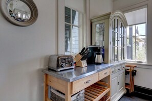 Cozinha com bancada de madeira, torradeira, cafeteira e porta-facas.
