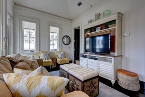 A living room with a sofa, armchairs, a television, and a fireplace. - Hartsfield Carriage, South of 30A, Steps to Beach & Towncenter, Sleeps 4, Gulf-Views! (Rosemary Beach)