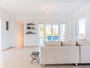 Una sala de estar moderna con un sofá, una mesita con libros y una estantería.