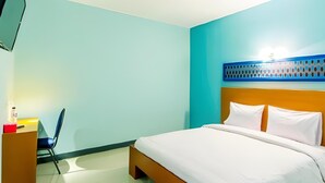 A hotel room with a bed, a desk, a chair, and a TV on the wall. - New Moonlight Hotel (Bandung)