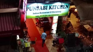 A restaurant named "PUNJABI KITCHEN" with a sign indicating it is an Indian Restaurant & Dormitory. - East & West Dormitory And Guesthouse (Phnom Penh)