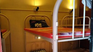 A bunk bed room with a single bed on the top bunk and a lower bunk. - East & West Dormitory And Guesthouse (Phnom Penh)