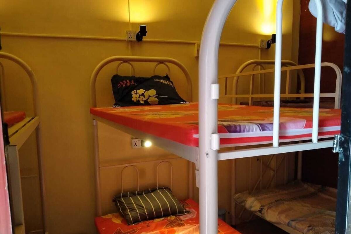 Une chambre avec un lit superposé, un lit simple en haut et un lit en bas.