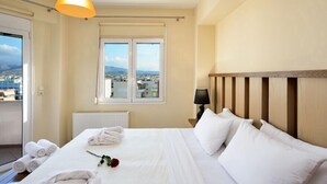 Una habitación de hotel con cama, ventana con vistas, un radiador y una lámpara.