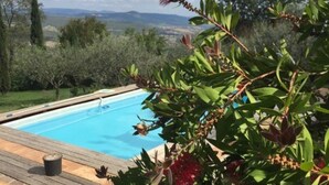 A pool with a wooden deck and a view of the countryside. - Guest house with a large terrace right by the pool (Murci)