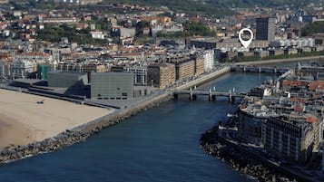 Vista aérea de una ciudad costera con un río, un puente y una playa.