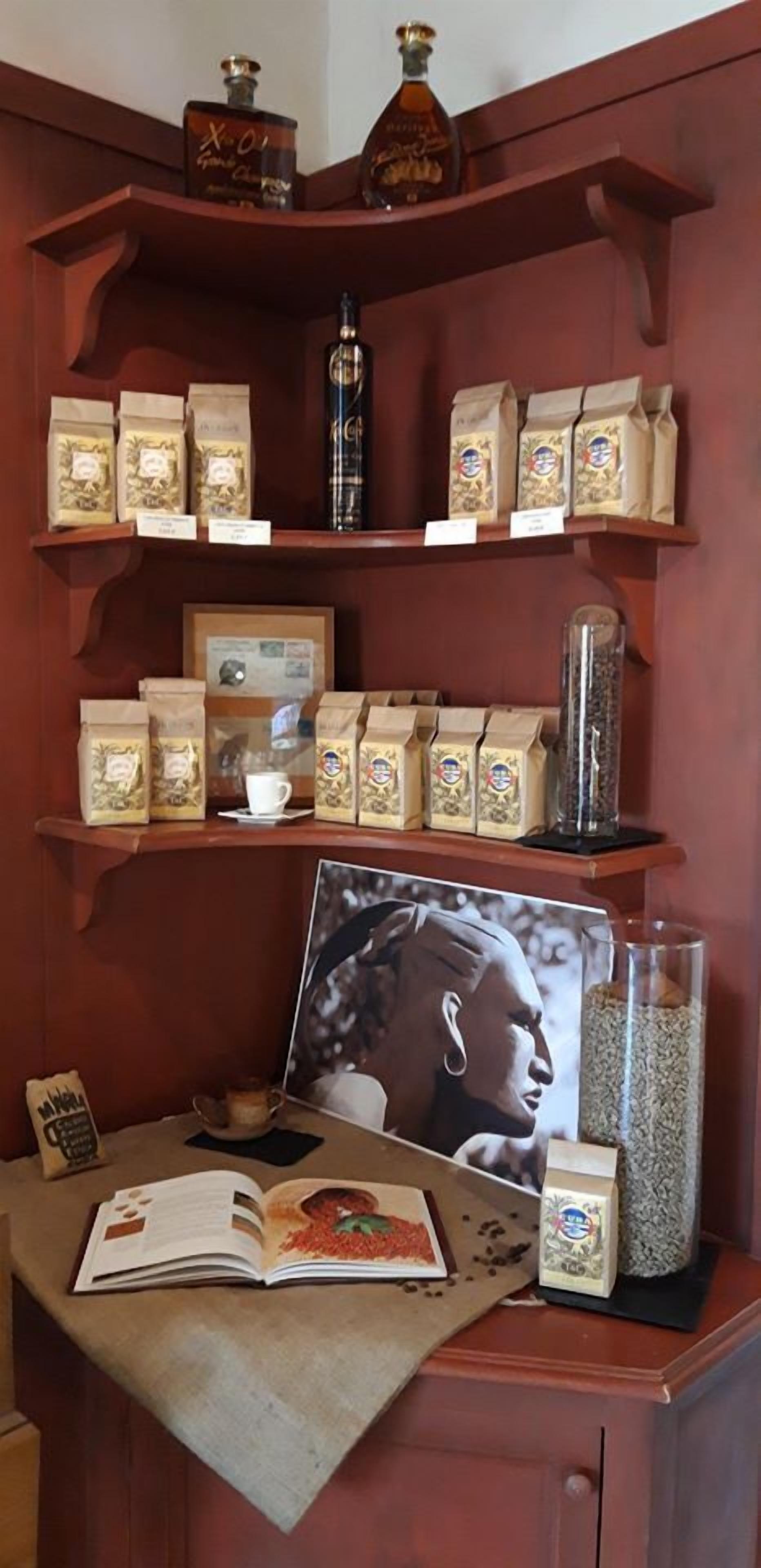Un estante de madera con bolsas de café, un cuadro enmarcado y un libro.