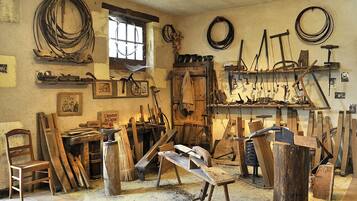 Un atelier équipé de divers outils et matériels, notamment des marteaux, des planches et un établi.