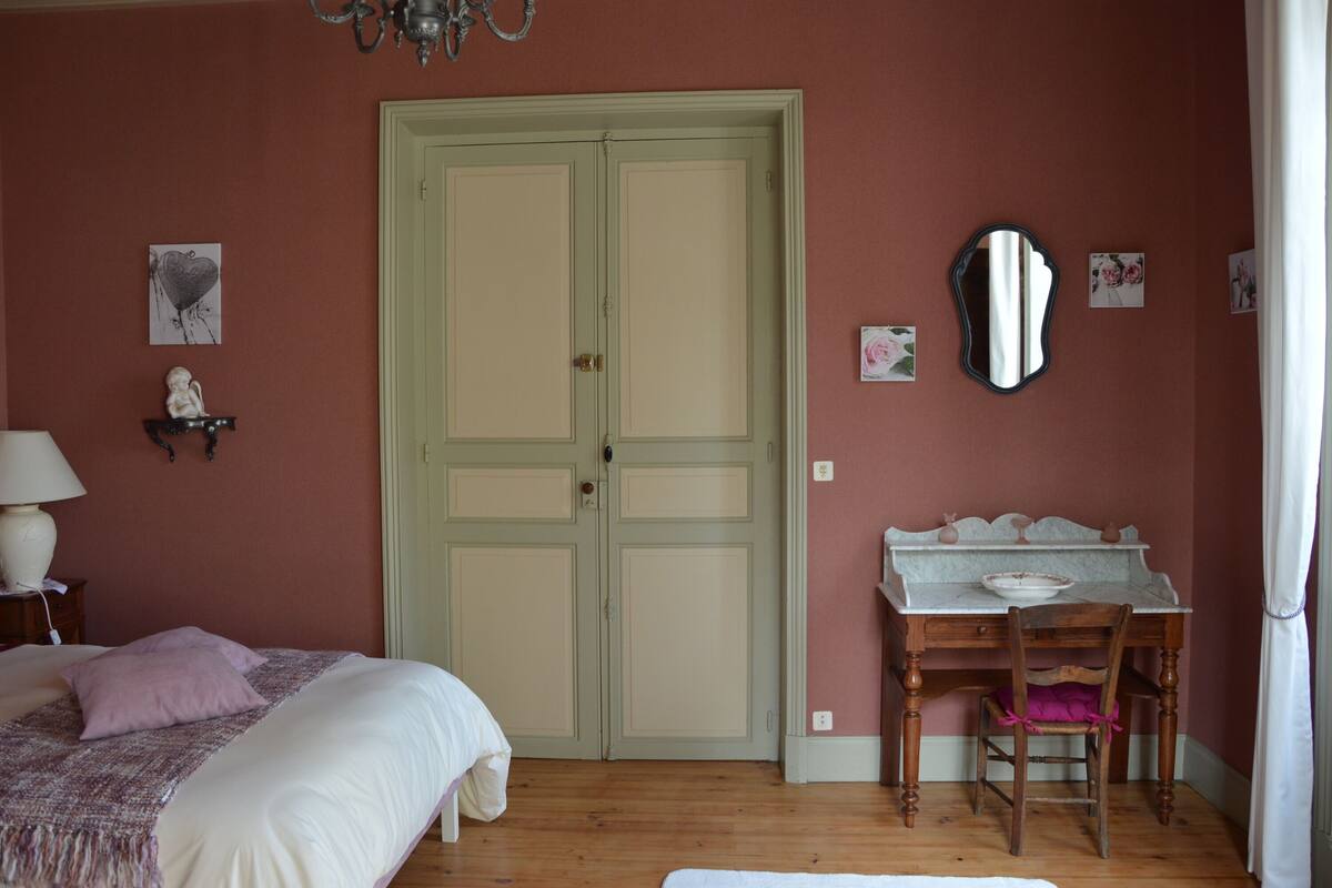 Un dormitorio con cama, escritorio y armario.