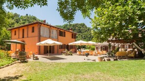 A villa with a patio area, outdoor seating, and a barbecue setup. - Agriturismo Rio Verde (Sasso Marconi)