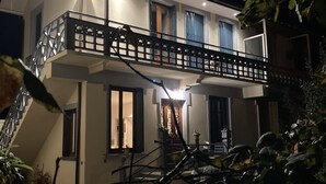 Une maison à deux étages avec un balcon, un escalier et un petit jardin.