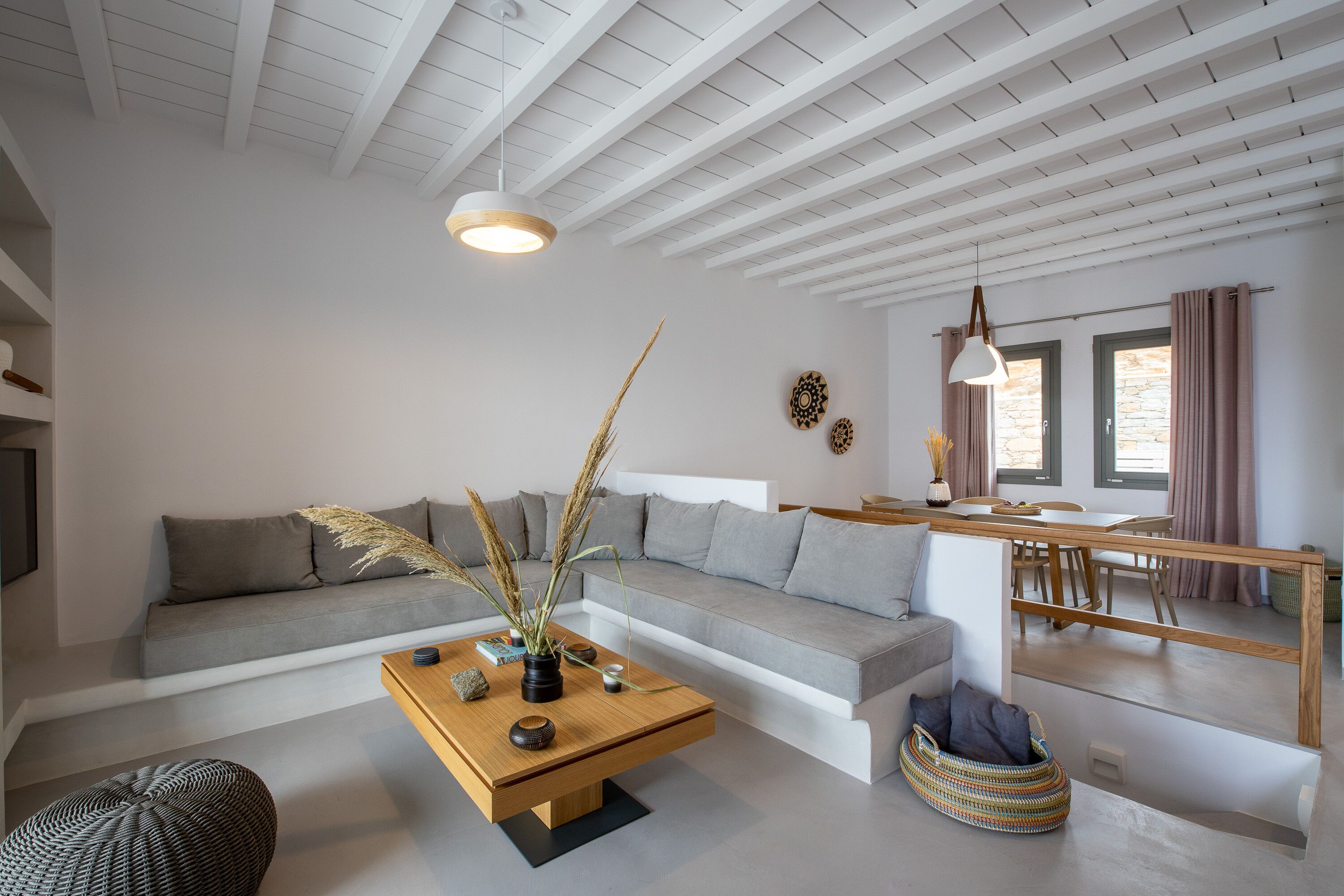 Una sala moderna con un sofá, una mesa de centro y una zona de comedor con una mesa y sillas.