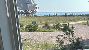 Een strandhuis met balkon en uitzicht op de oceaan.