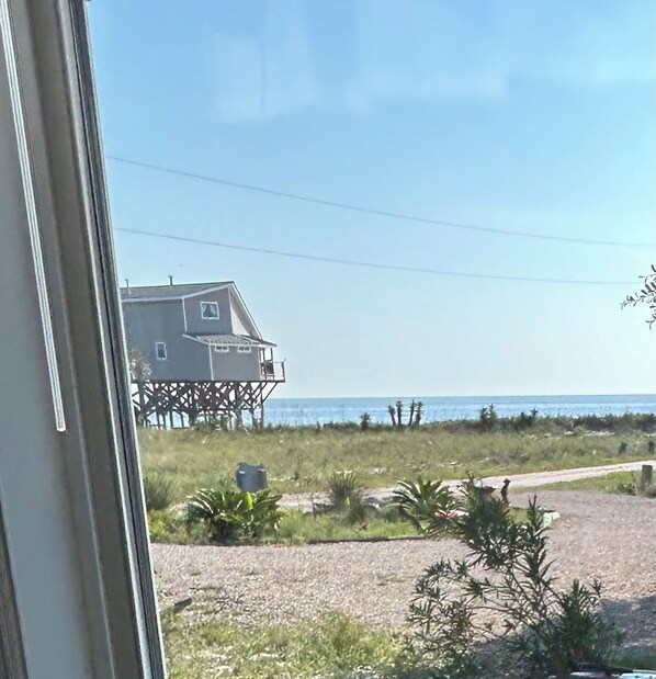 A beach house with a balcony and a view of the ocean.