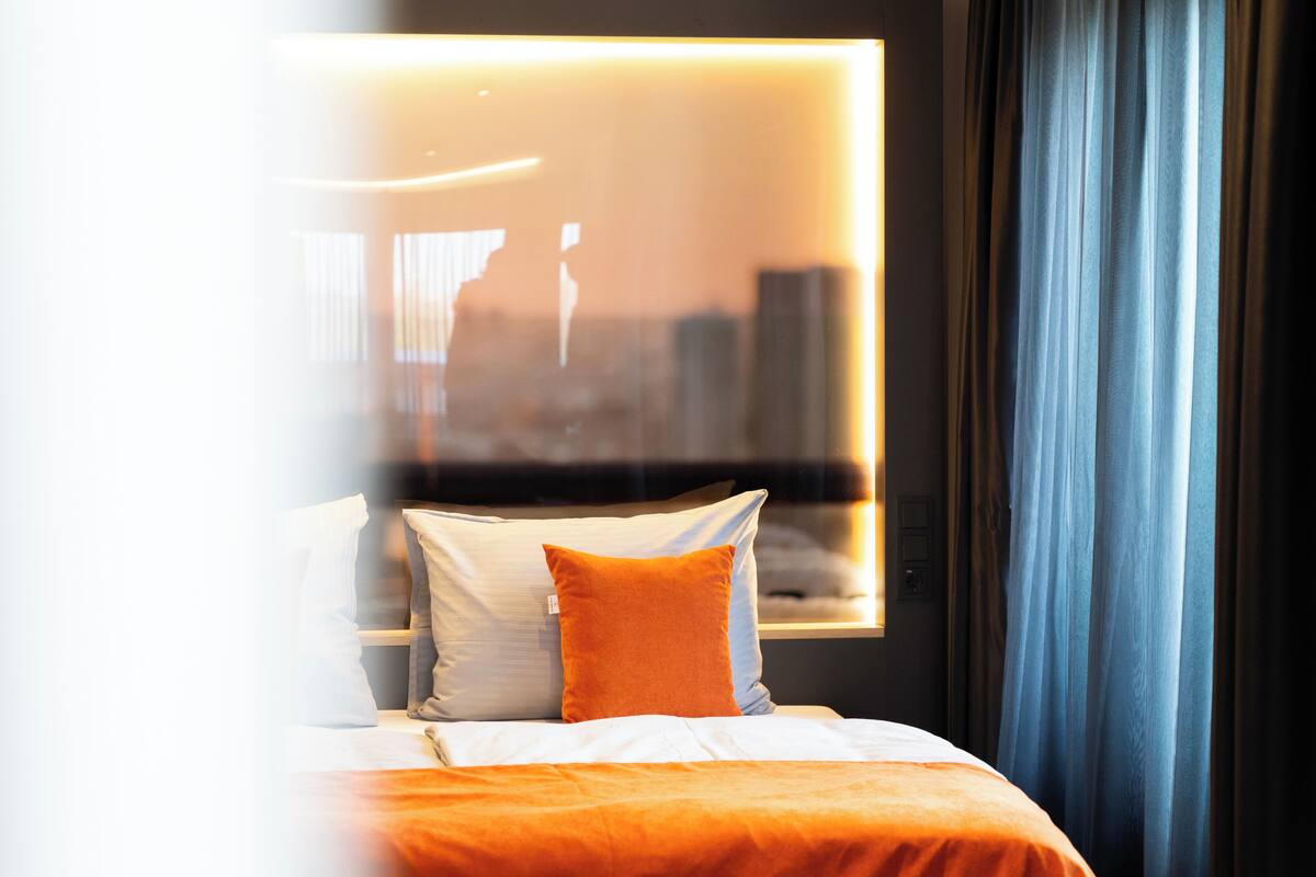 Une chambre d’hôtel avec un lit, une fenêtre et des rideaux.