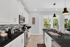 Airy Elegance: Experience the perfect blend of airiness and style in our living area, seamlessly connected to the open-concept kitchen for a chic and welcoming atmosphere. - Pool Home! 5BR w Patio & Free Parking near Disney (Kissimmee)