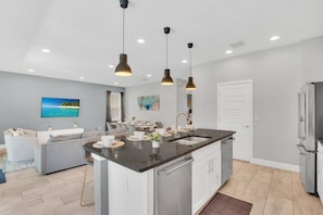 Airy Elegance: Experience the perfect blend of airiness and style in our living area, seamlessly connected to the open-concept kitchen for a chic and welcoming atmosphere. - Pool Home! 5BR w Patio & Free Parking near Disney (Kissimmee)