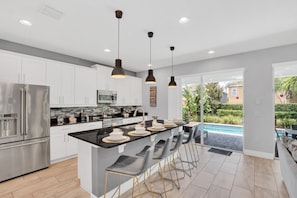 Enchanting Kitchen Area of the Apartment in Kissimmee Florida - Integrated appliances for a seamless and stylish appearance - Functional layout designed for efficient meal preparation - Breakfast Bar for convenience - Ample Natural Light - Pool Home! 5BR w Patio & Free Parking near Disney (Kissimmee)