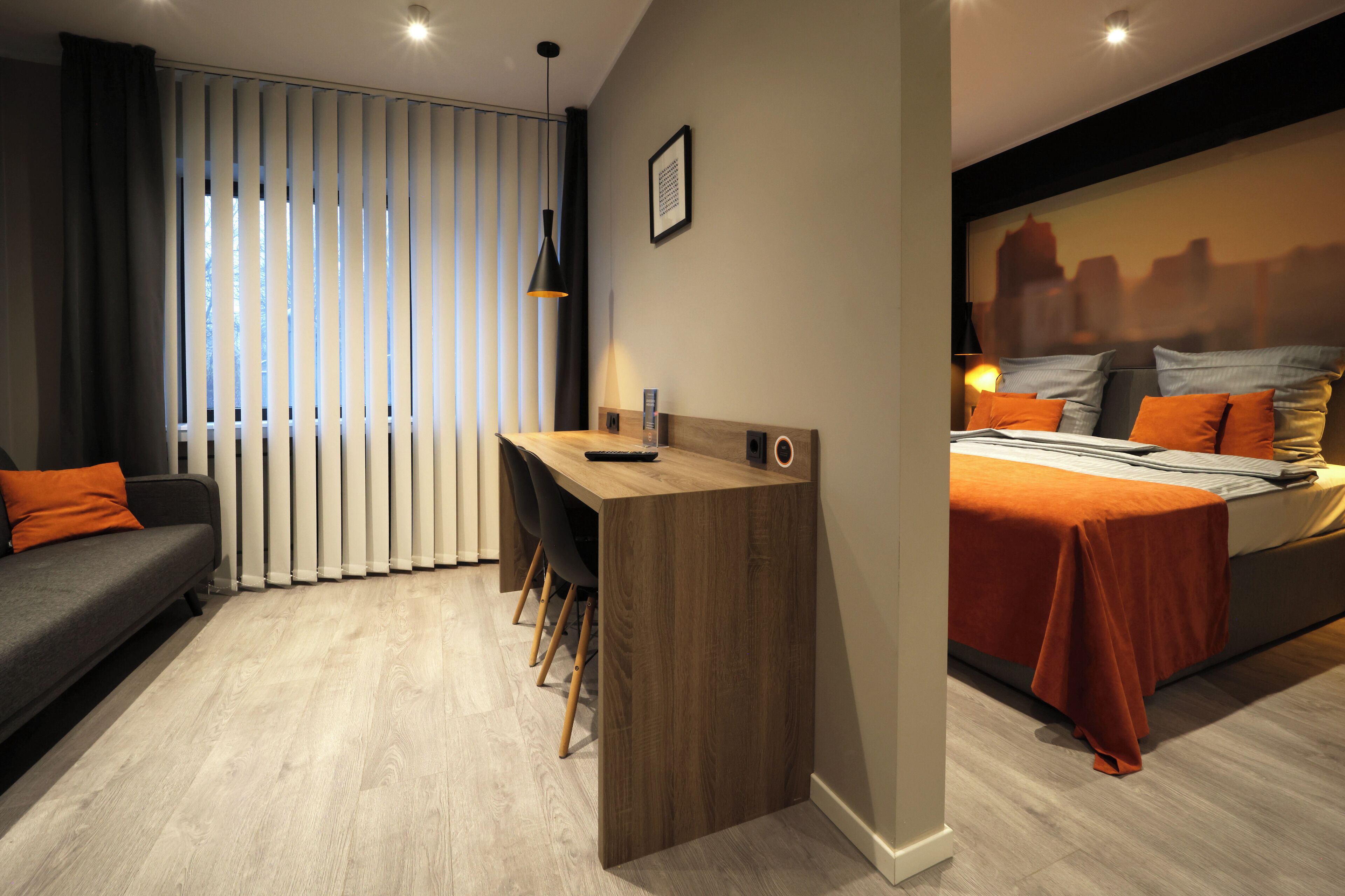 Una habitación de hotel moderna con una cama, un escritorio y un sofá.
