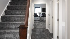 A carpeted staircase with a wooden handrail leading to a room with a table and chairs. - 2 Bedrooms Sleeps 6 Near Top Blackpool Attractions (Blackpool)
