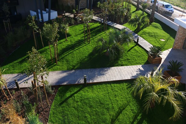 A well-maintained garden with a variety of plants and a paved walkway.