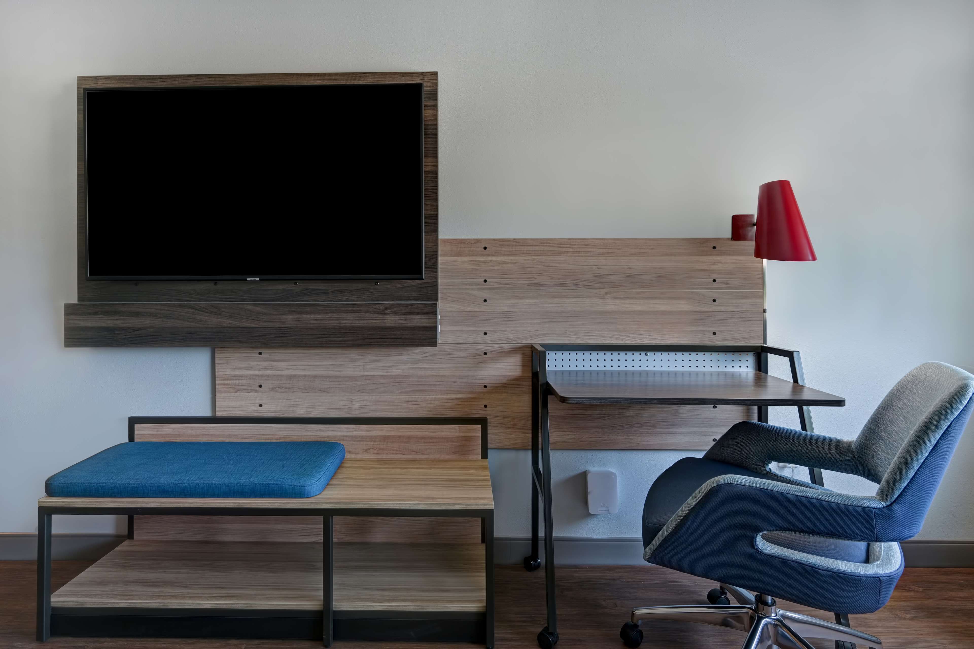 A modern room with a bed, a desk, and a chair.