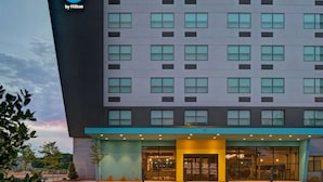 A modern hotel building with a flat facade, multiple windows, and a prominent entrance with glass doors.