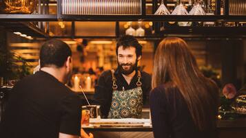 A bar setting with a bartender, a customer, and a bar counter.