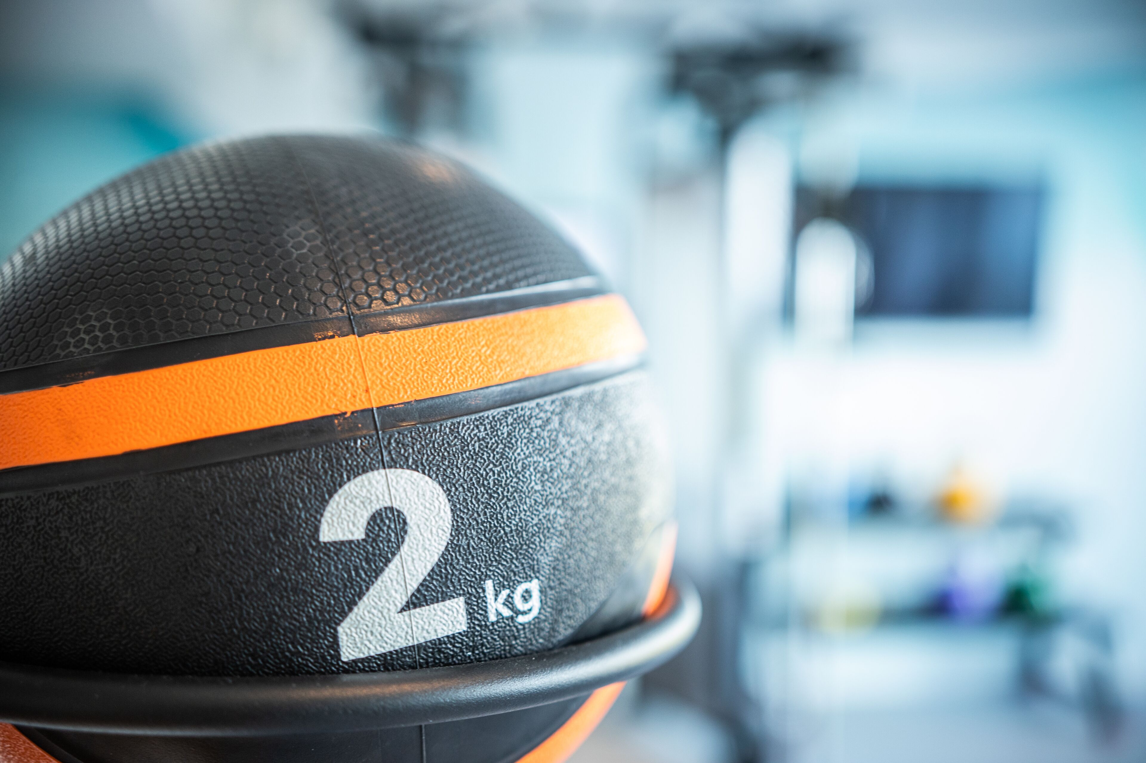 Primer plano de un balón de baloncesto negro y naranja con el número 2 y la etiqueta '2 kg'.